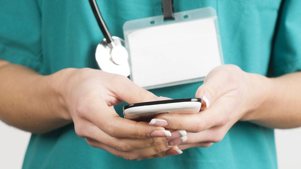 doctor sosteniendo móvil en sus manos  CRM integrado a WhatsApp.