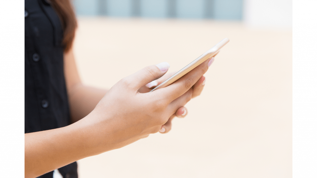 manos de mujer sosteniendo smart phone aumentar ventas por WhatsApp